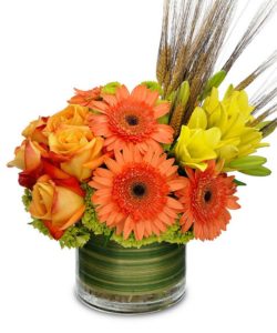 Yellow gerbera orange and yellow roses and yellow lilies with green accents