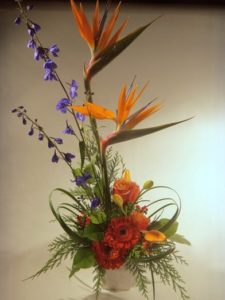 This sophisticated arrangement features Bird of Paradise, a premium exotic flower, as well as Delphinium, Gerbera Daisies, Roses and Lillies, stylishly arranged for a modern feel.