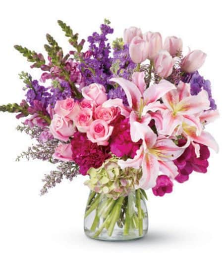 And this dramatic floral arrangement of roses, lilies, tulips and more – in radiant, blushing shades of pink and purple – is fit for royalty!
