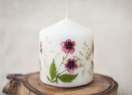 Candle with herbarium flowers. dried red flowers. on linen background