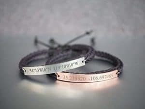 pair of leather bracelets with silver plate engraved with coordinates